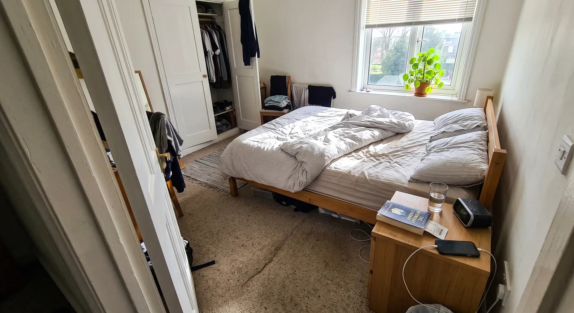 A bedroom with the blinds opened in the morning
